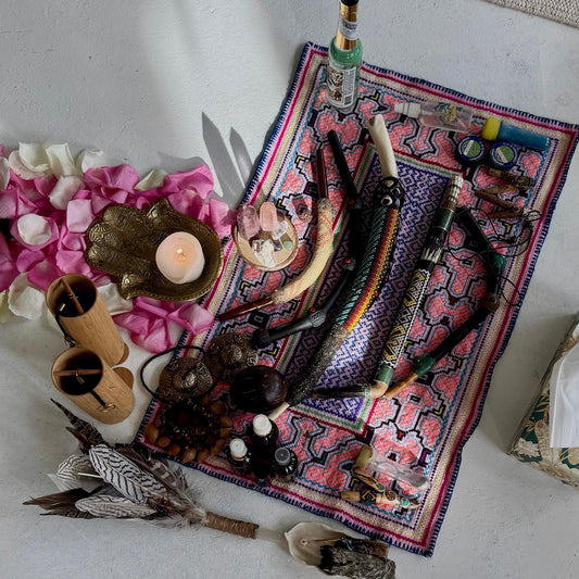 Various objects including candles, feathers, Tepi applicator for rapeh and shipibo altar cloth